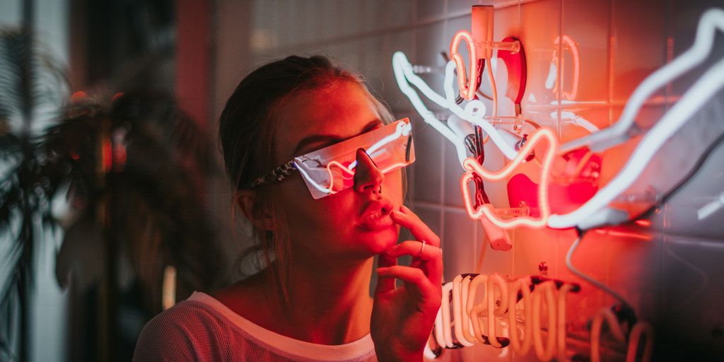 woman standing beside lighted neon lights